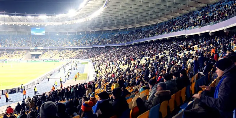 Fans are watching football match at the stadium